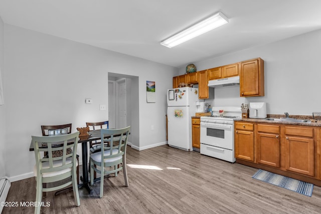 kitchen with white appliances, light hardwood / wood-style floors, sink, and a baseboard heating unit