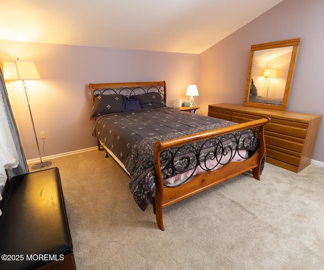 carpeted bedroom featuring lofted ceiling and baseboards