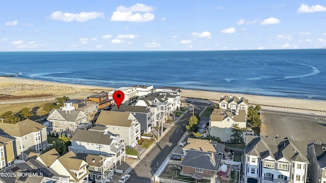 birds eye view of property with a water view and a beach view