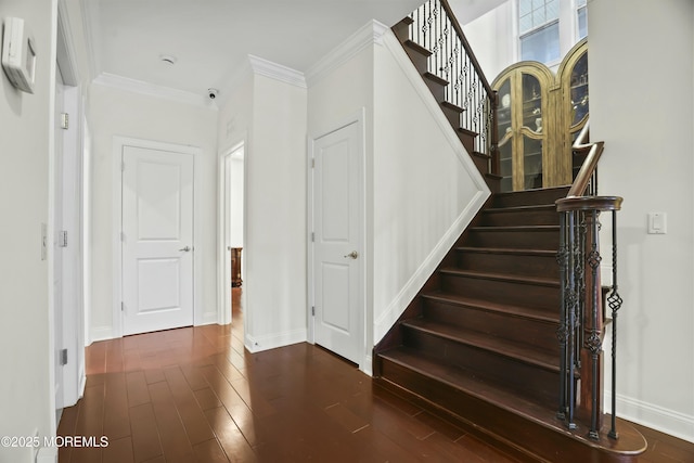 stairway with crown molding and hardwood / wood-style flooring