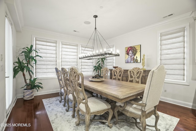 dining room with crown molding, dark wood-type flooring, and a notable chandelier