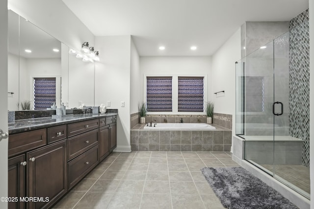 bathroom featuring shower with separate bathtub, vanity, and tile patterned floors