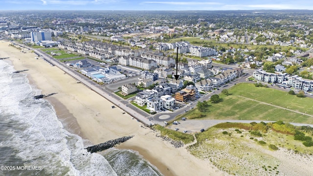 birds eye view of property featuring a beach view and a water view