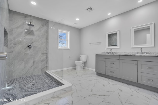 bathroom with tiled shower, vanity, and toilet