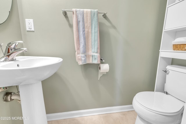 bathroom with sink, toilet, and tile patterned flooring