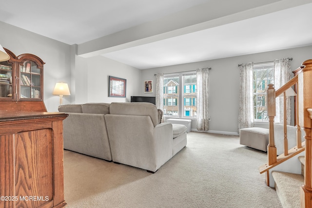 carpeted living room with beamed ceiling