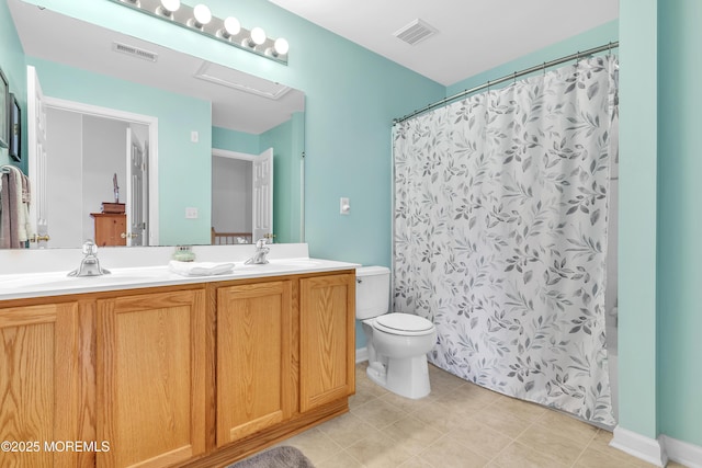 bathroom featuring vanity, tile patterned floors, and toilet