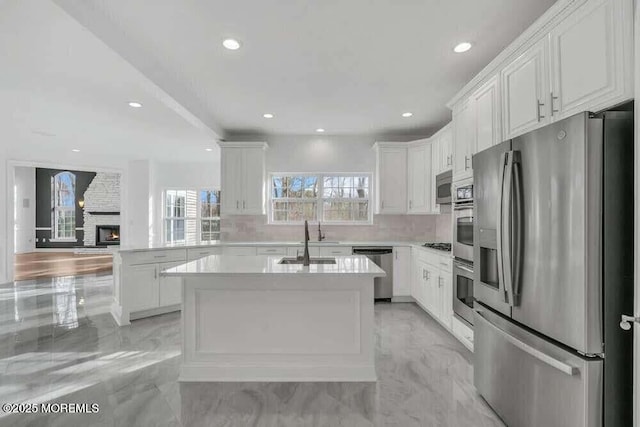 kitchen with appliances with stainless steel finishes, sink, white cabinets, and kitchen peninsula