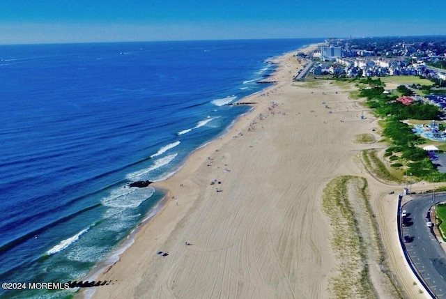 birds eye view of property with a water view and a view of the beach