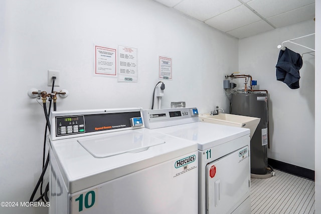 washroom featuring water heater, separate washer and dryer, and baseboards