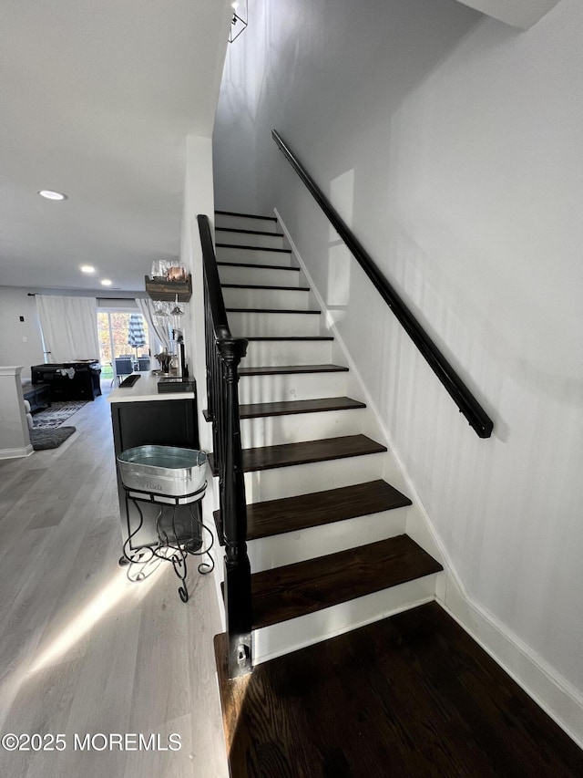 stairs with recessed lighting, baseboards, and wood finished floors