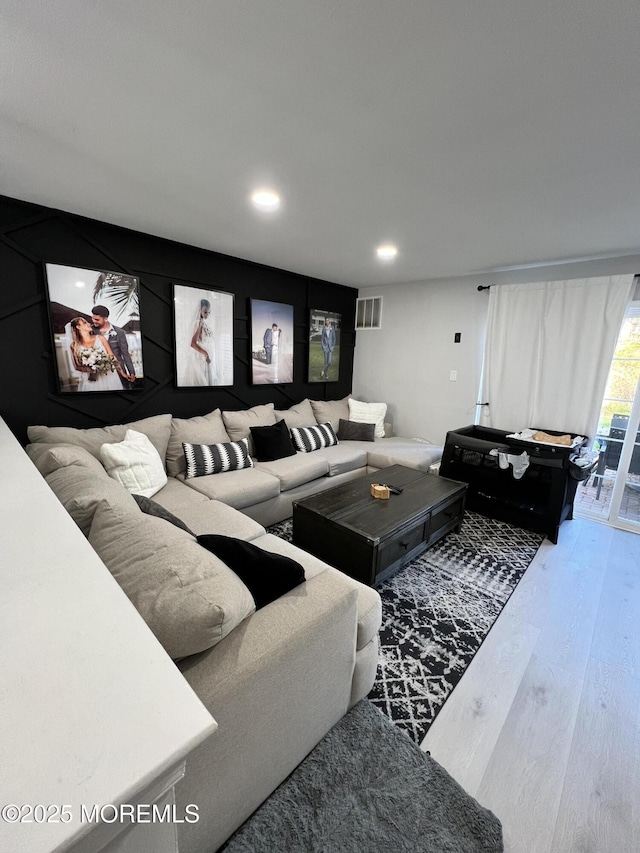 living area featuring recessed lighting, visible vents, and wood finished floors