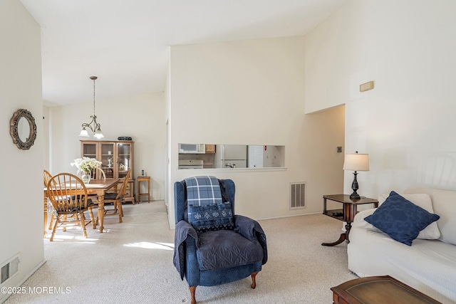 carpeted living room with high vaulted ceiling