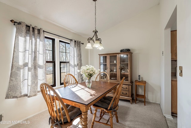 dining room featuring lofted ceiling and carpet floors