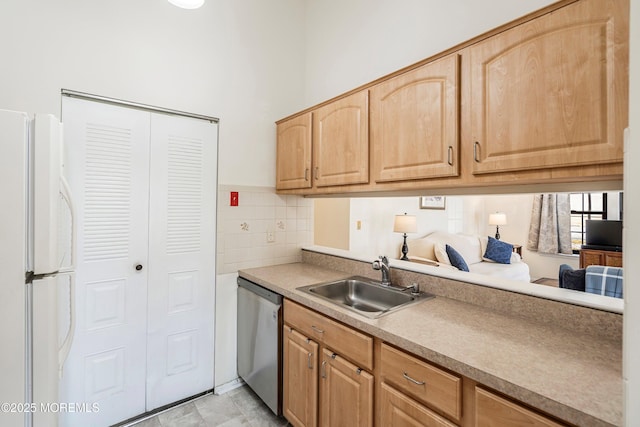 kitchen featuring light brown cabinetry, sink, stainless steel dishwasher, white fridge, and backsplash