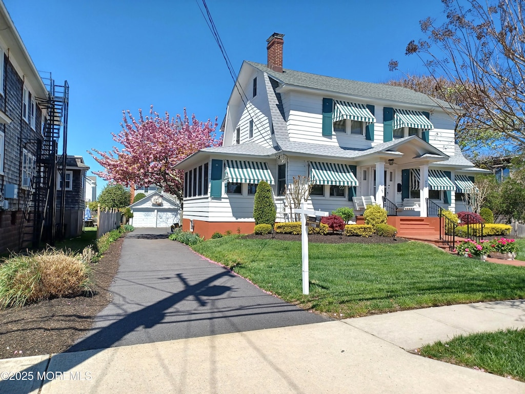 630 Main Ave, Bay Head, NJ 08742 - view of front of house with a chimney, an outbuilding, a front lawn, a gambrel roof, and a shingled roof