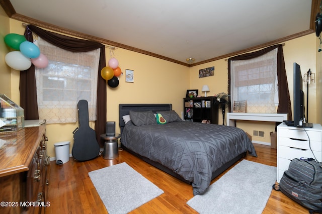 bedroom with hardwood / wood-style flooring and ornamental molding