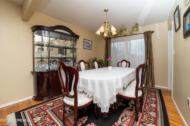 dining area featuring hardwood / wood-style flooring and a chandelier