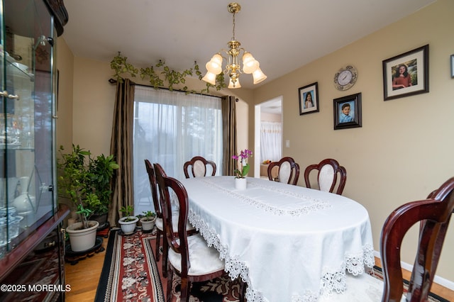 dining area with hardwood / wood-style flooring and a chandelier