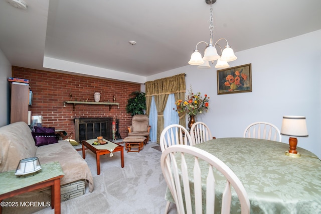 dining space with brick wall, a fireplace, light carpet, and a notable chandelier