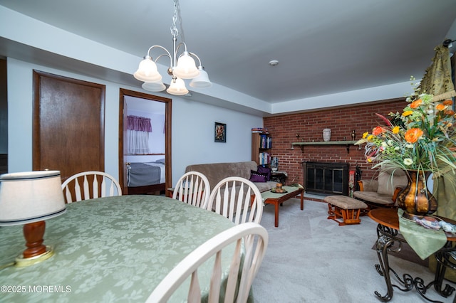 carpeted dining area featuring brick wall, an inviting chandelier, and a fireplace