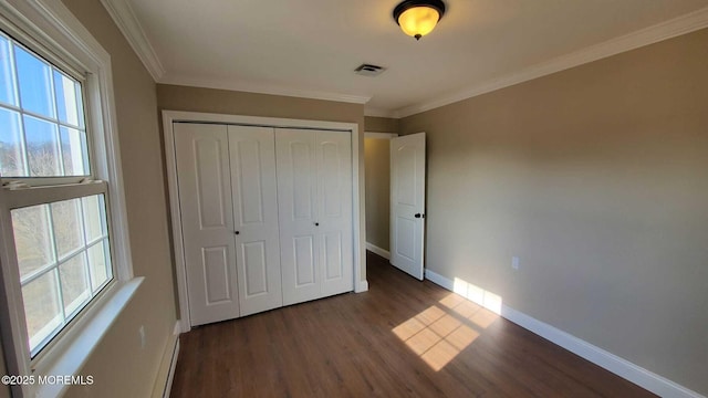 unfurnished bedroom featuring ornamental molding, dark hardwood / wood-style flooring, and a closet