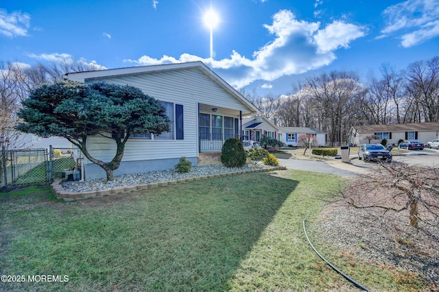 view of home's exterior featuring a lawn, fence, and a gate