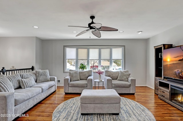 living room with ceiling fan and light hardwood / wood-style flooring