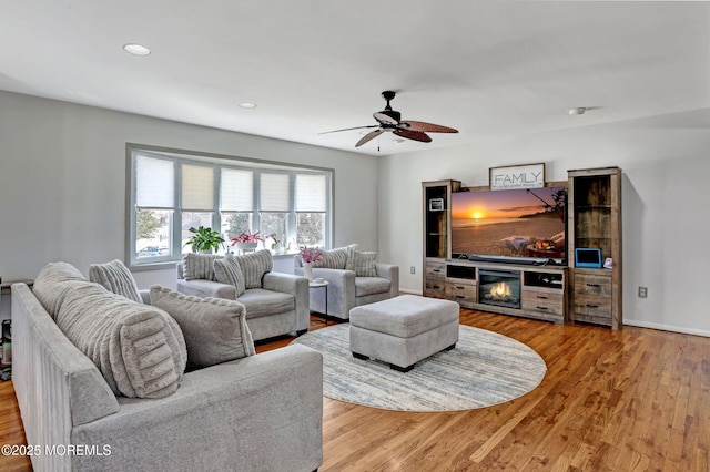 living room with ceiling fan and light wood-type flooring