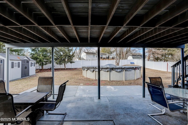 view of patio with a covered pool and a storage unit