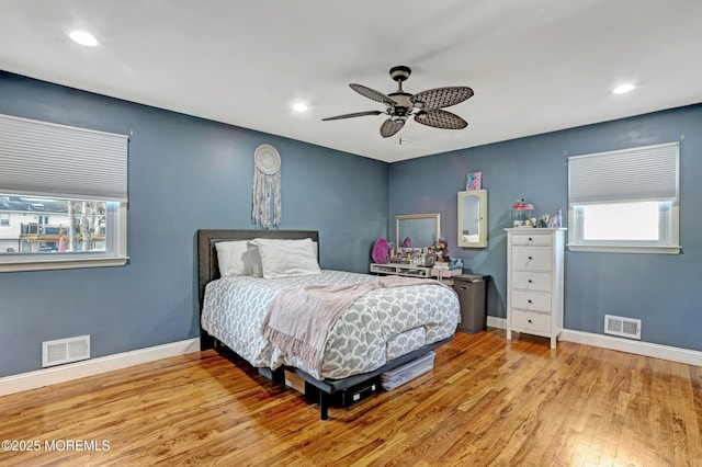 bedroom with multiple windows, ceiling fan, and light wood-type flooring