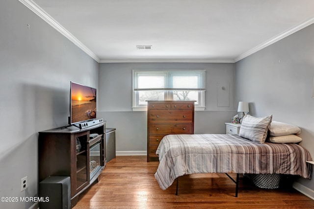 bedroom with crown molding and light hardwood / wood-style flooring