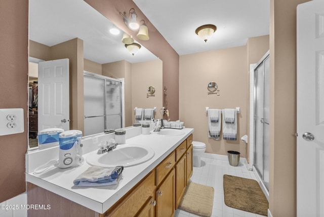 bathroom featuring double vanity, a stall shower, a sink, and toilet