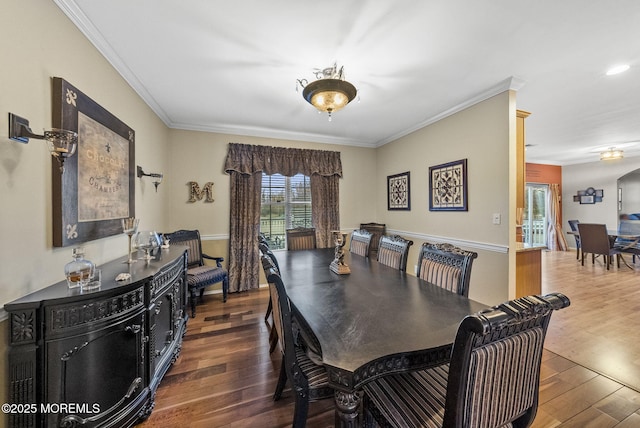 dining room featuring wood finished floors and crown molding