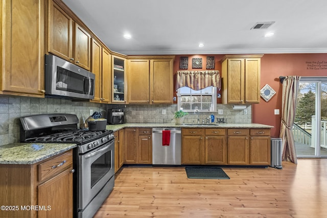 kitchen featuring stainless steel appliances, a sink, visible vents, and brown cabinets