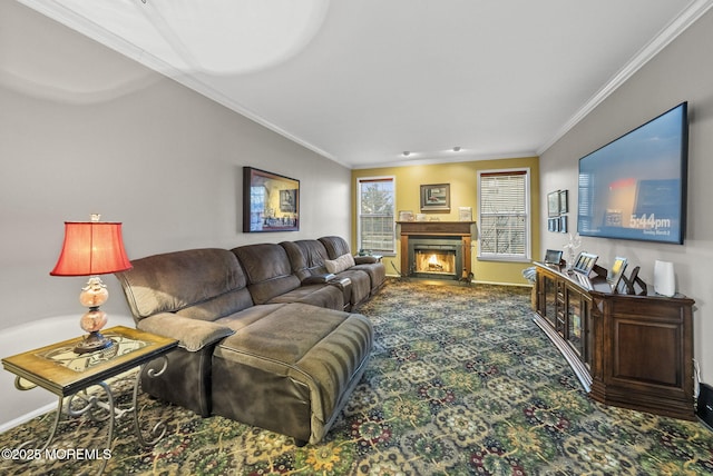 living room with carpet floors, a warm lit fireplace, baseboards, and crown molding