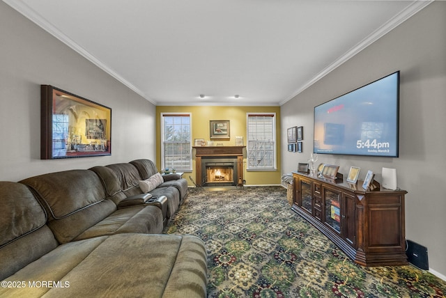 carpeted living area with crown molding, a lit fireplace, and baseboards