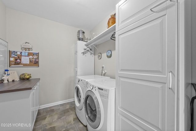 clothes washing area with baseboards, laundry area, and washer and dryer