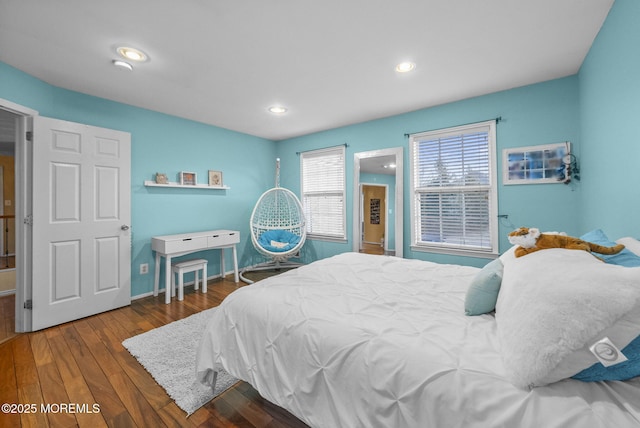 bedroom with baseboards, wood finished floors, and recessed lighting