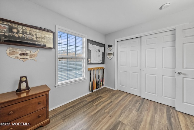 bedroom with a closet, baseboards, and wood finished floors