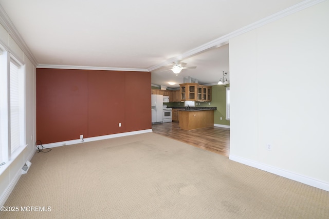 unfurnished living room featuring lofted ceiling, sink, crown molding, ceiling fan, and carpet