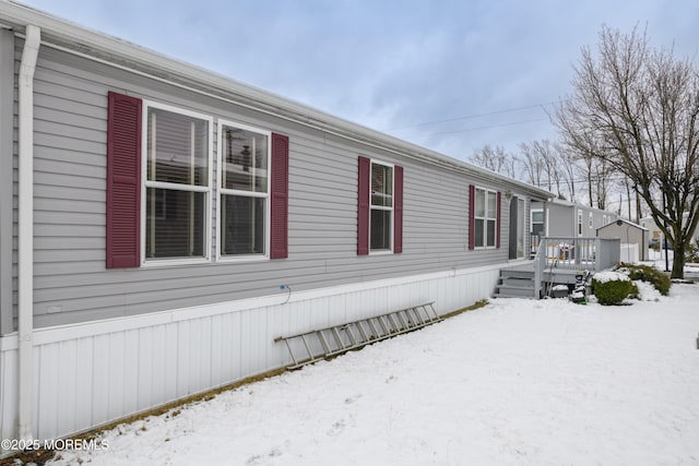 view of snow covered exterior with a deck