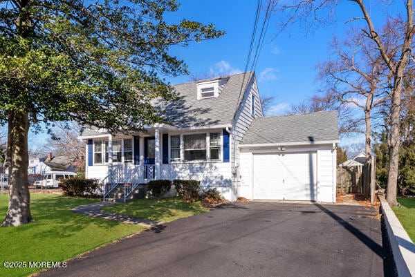 cape cod-style house featuring a front yard and a garage