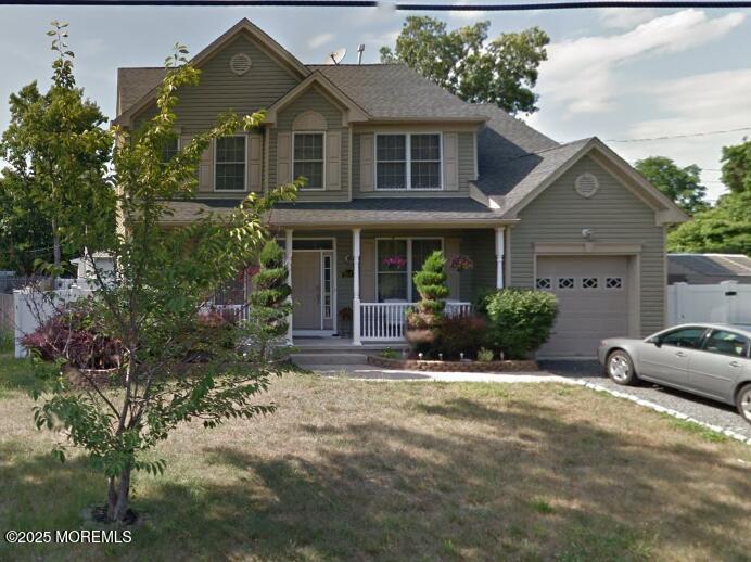 view of front of house featuring a garage, a front lawn, and a porch