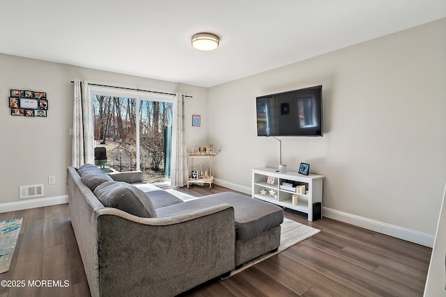 living room with dark wood-style flooring, visible vents, and baseboards