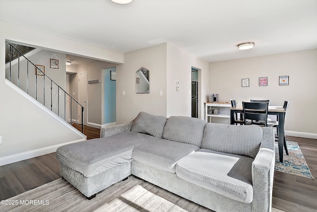 living room featuring stairs, wood finished floors, and baseboards