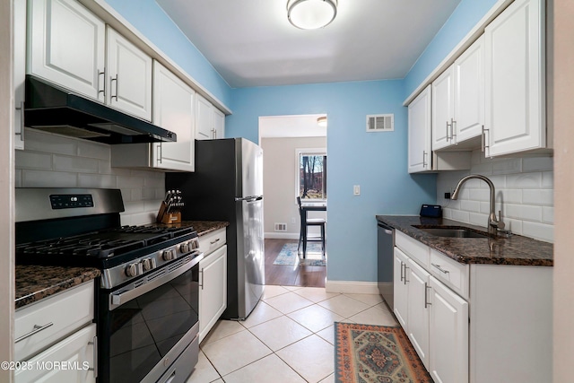 kitchen with visible vents, white cabinets, appliances with stainless steel finishes, under cabinet range hood, and a sink