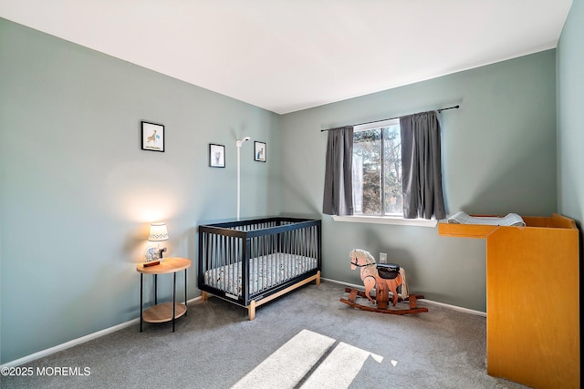 carpeted bedroom with a crib and baseboards