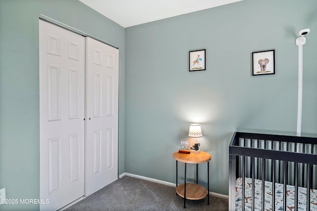 bedroom with a crib, a closet, dark carpet, and baseboards