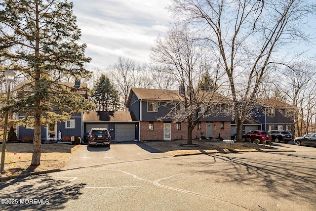 view of front facade with concrete driveway, brick siding, and an attached garage